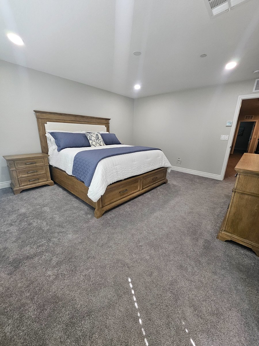 Upstairs master bedroom with two side table, dresser and extra linen