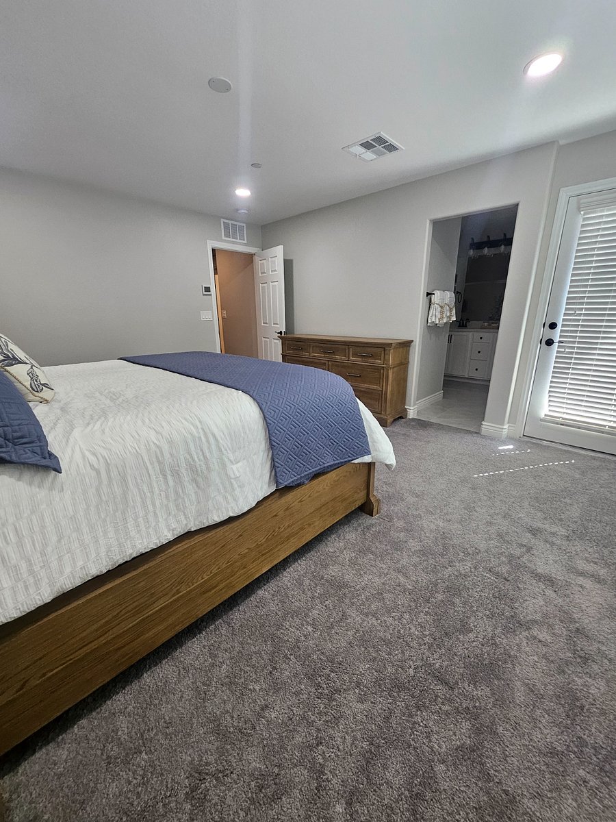 Upstairs master bedroom with two side table, dresser and extra linen