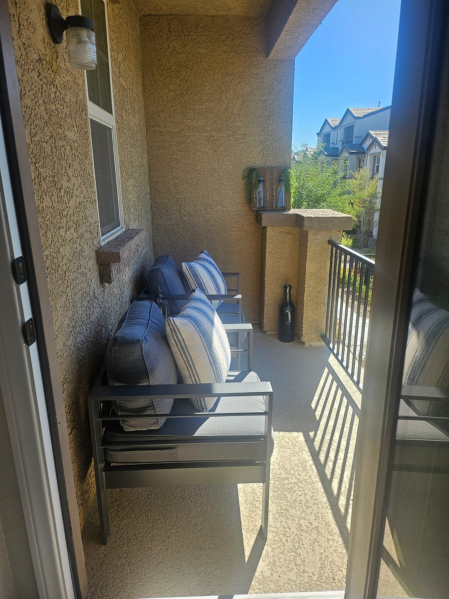 Upstairs patio with two patio chairs and side table