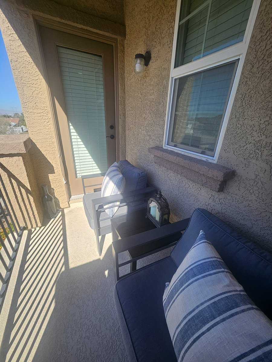 Upstairs patio with two patio chairs and side table