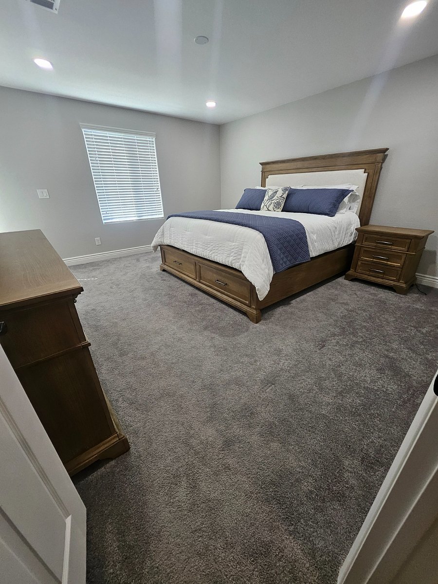 Upstairs master bedroom with two side table, dresser and extra linen