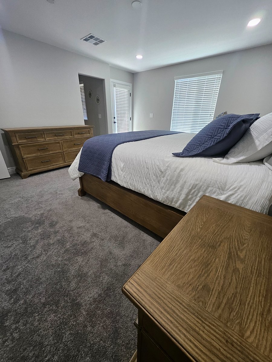 Upstairs master bedroom with two side table, dresser and extra linen