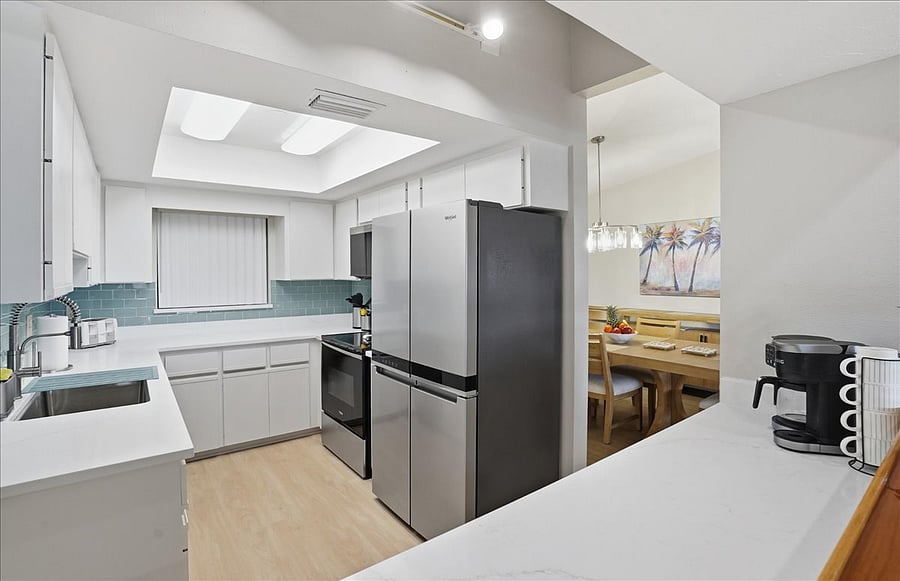 Bar counter in kitchen overlooks breakfast bar and living area