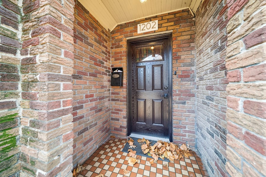 The inviting covered front porch features a beautiful arched doorway, adding to the home's historic charm.