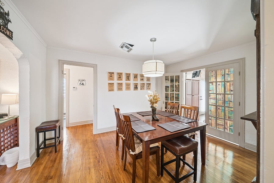 A second view of the formal dining room showcases its spacious layout and timeless character. Surrounded by original architectural details and historic dcor, this inviting space comfortably accommodates family meals, game nights, or gatherings with friends. The blend of vintage charm and modern conveniences makes the dining room a memorable part of this unique 1920s Tulsa home.