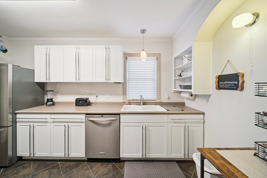 This view of the kitchen highlights the generous countertop workspace, making meal preparation easy and convenient. The kitchen features a new dishwasher (installed June 2025), along with a countertop microwave, toaster, and blender. Whether you're preparing a quick breakfast before work or cooking a full dinner, you'll find the kitchen well-equipped with the appliances and workspace needed to feel right at home.