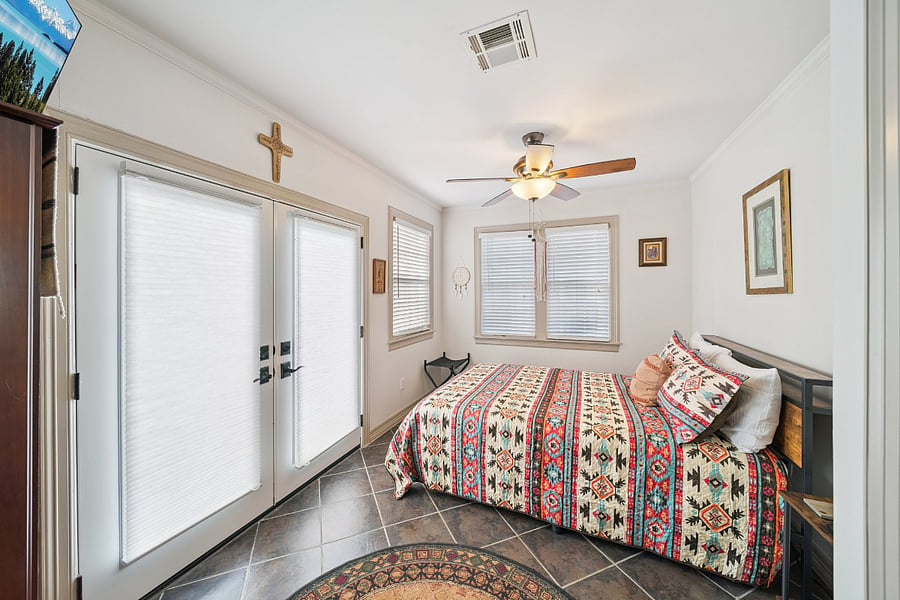 Bedroom #3 is conveniently located just off the dining room, offering added privacy and comfort. This spacious room features a queen-size bed, two bedside tables, a luggage rack, wardrobe cabinet, and a Smart TV. French doors open directly onto the back patio, providing easy access to the outdoor seating area and allowing plenty of natural light into the room.
For added convenience, Bedroom #3 also includes a private half bathroom, making it an ideal retreat for guests seeking extra privacy during their stay.