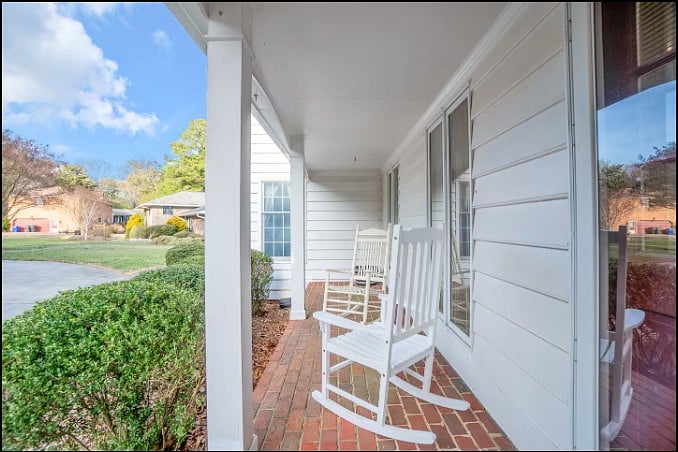 Relax with your morning coffee on the covered brick porch, equipped with classic white rocking chairs.