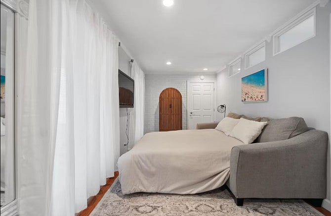 Spacious queen-size bedroom featuring a comfortable mattress, soft linens, and a calming, modern design for a restful nights sleep.