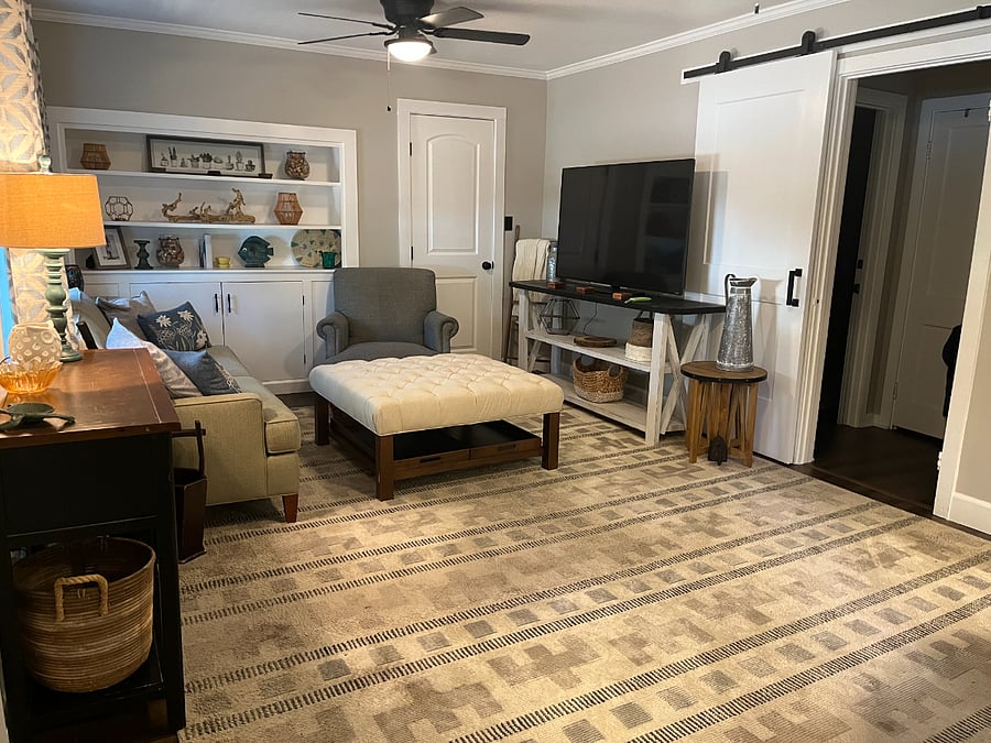 Living room w/ barn door separating the bedrooms and bath