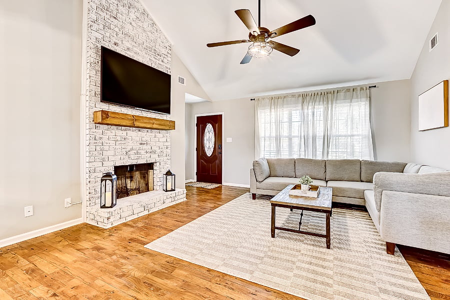 Living room with smart TV, sofa seating, fireplace and natural light