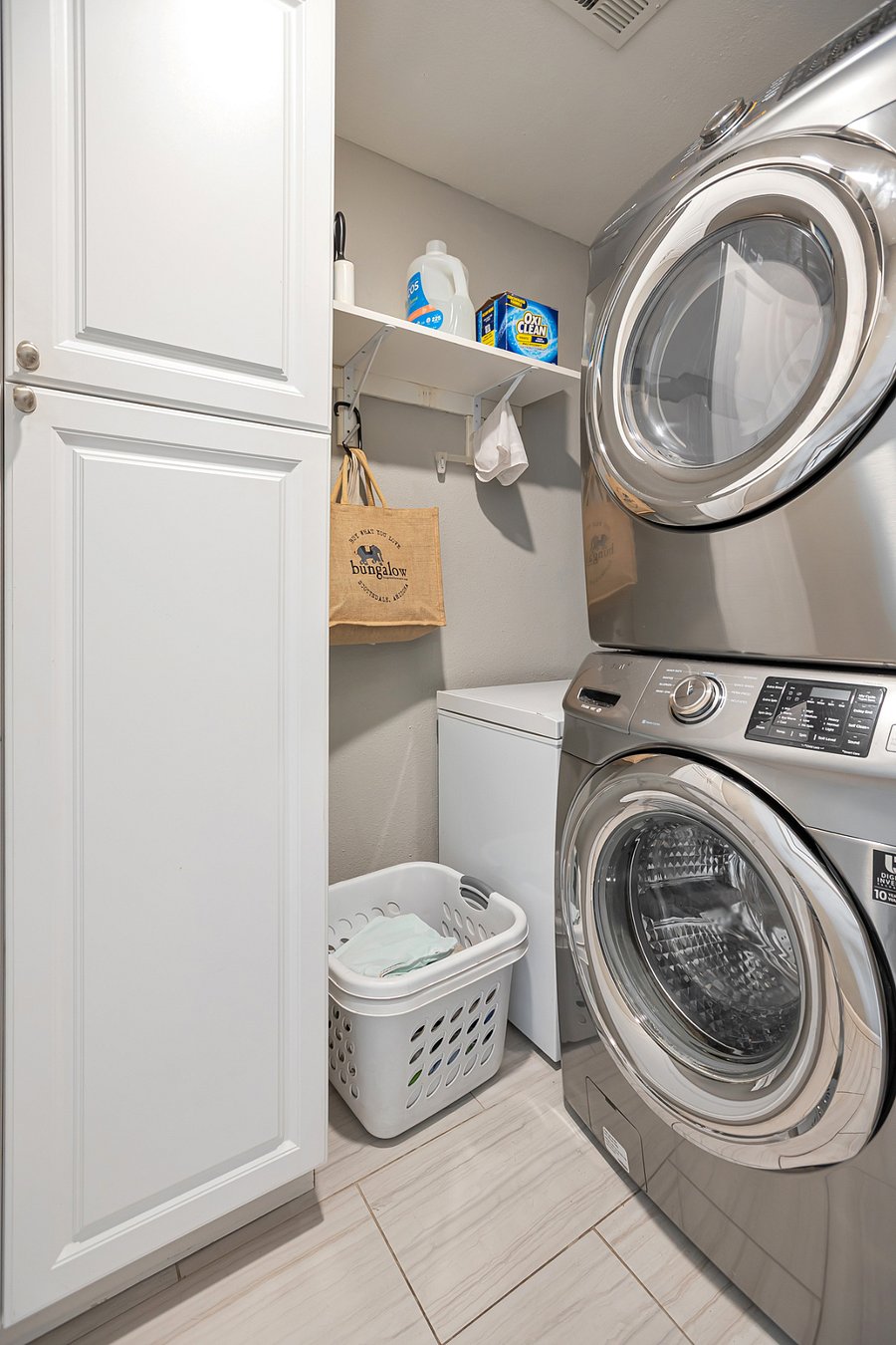 Laundry room w/stacked Samsung stainless washer and dryer, built-in pantry storage and additional chest freezer