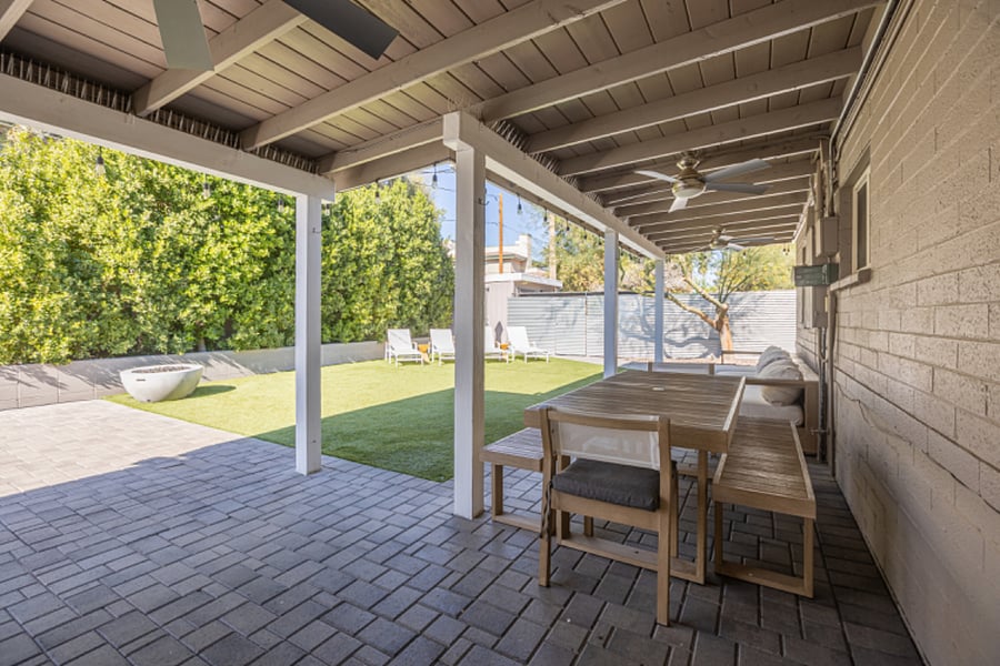 Large covered patio featuring ceiling fans for warm Arizona days and a gas fireplace for comfortable outdoor living