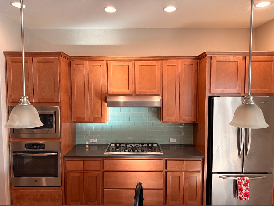 microwave, over, stove top, fridge and cabinets in kitchen
