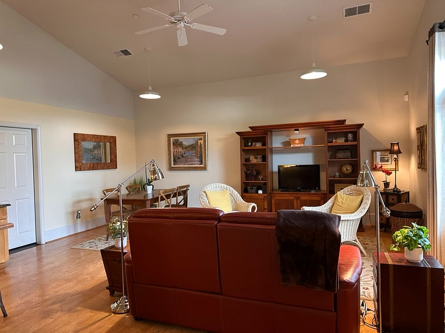 View from foyer to living and dining areas. Storage available in TV cabinet with remote and DVD player. Dining table expands if needed for digital nomads.