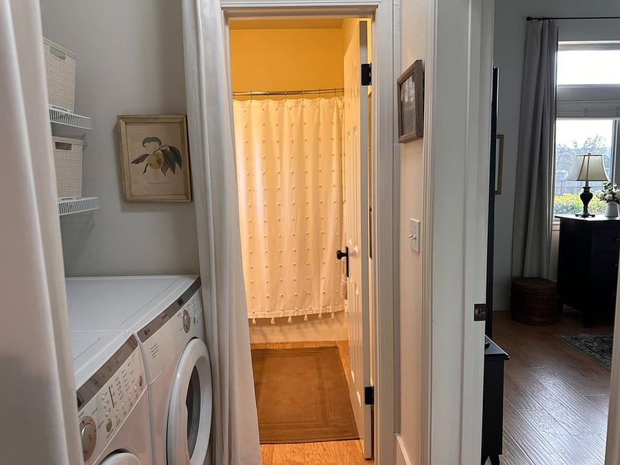 View from foyer to the bathroom, with laundry alcove, bedroom and hall closet on either side.