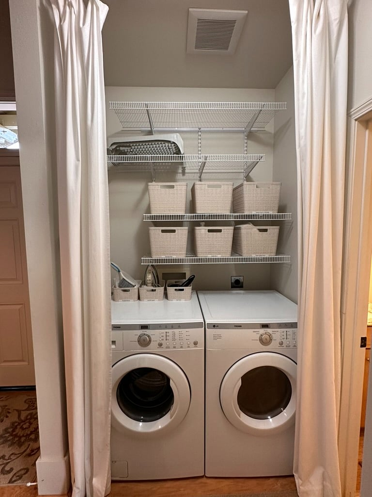 Washer, dryer, laundry, cleaning supplies, iron with extra bins for personal items.