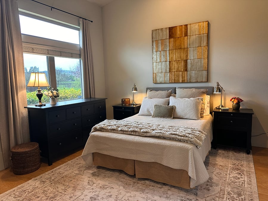 Duxiana queen bed with articulating headboard for reading. Soft linens, neutral blanket and quilt. 110v and USB charging stand next to bedside.