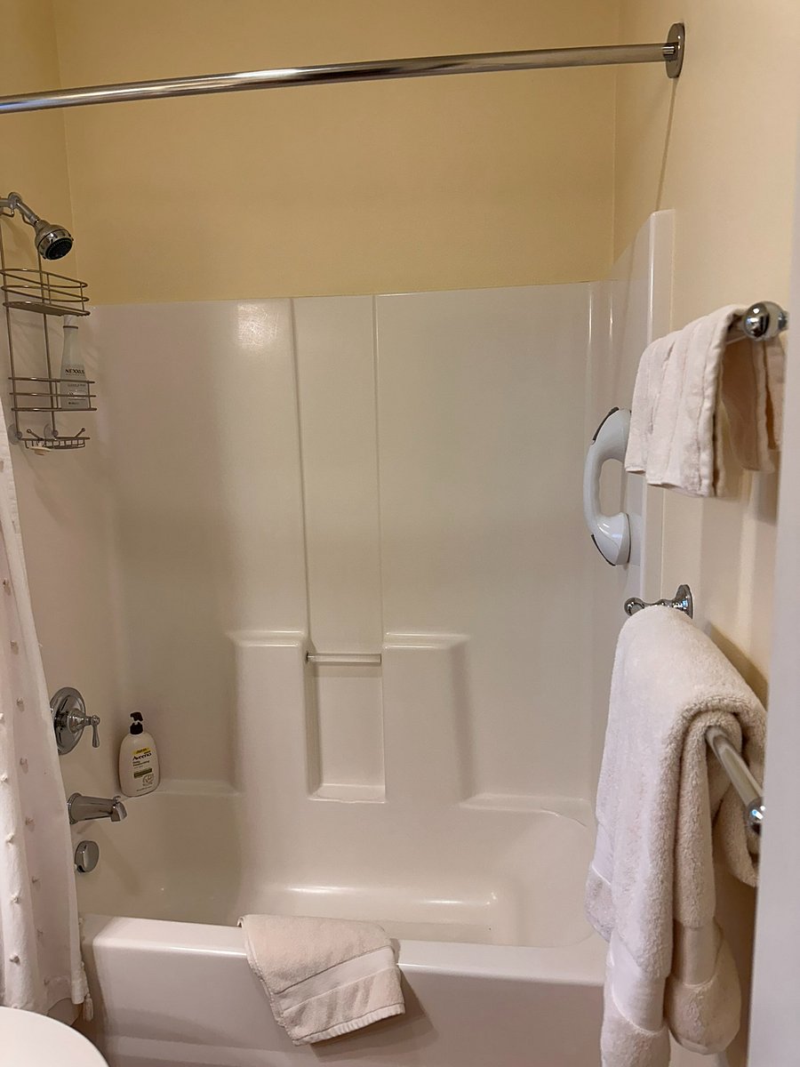 Shower over tub combo with shampoo and liquid soap. Plentiful towels and a safety handle for safe access.