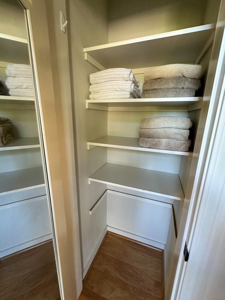 Hall linen closet storage for luggage and personal items.  Shark lift off vacuum, ironing board not pictured but available.