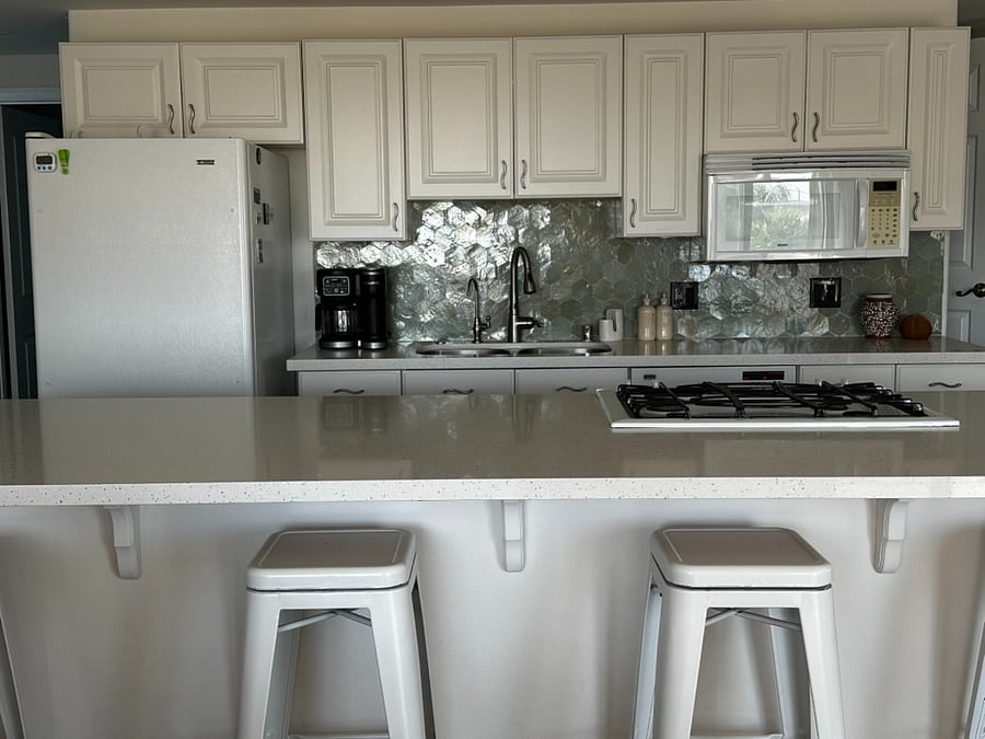 Kitchen on second floor with refrigerator, microwave, oven, stove, coffee maker, blender, toaster, dishes, utensils, glassware, pots and pans, and island seating