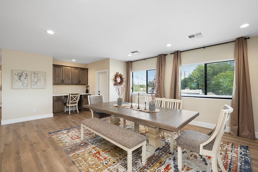 This expansive dining space pulls double duty. In addition to a large gathering table, this room boasts a dedicated built-in workspace nook, providing a quiet, productive corner for digital nomads or business travelers.