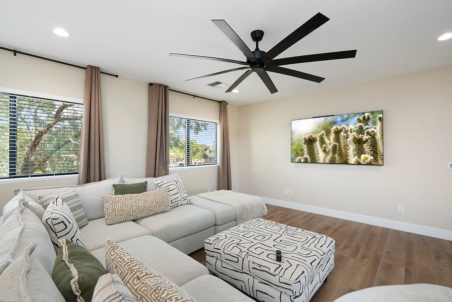 A large, flat-screen TV is mounted prominently on the wall, perfect for movie nights.