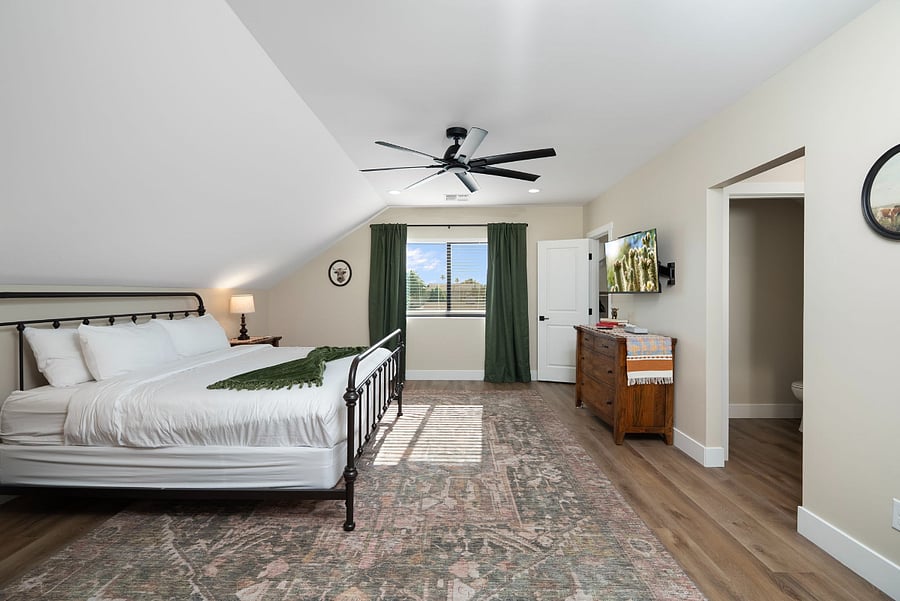 Retreat to a private, oversized sanctuary. Featuring unique architectural vaulted ceilings and a peaceful color palette, this expansive bedroom suite feels like a secluded loft retreat while offering all the luxury of a primary bedroom.