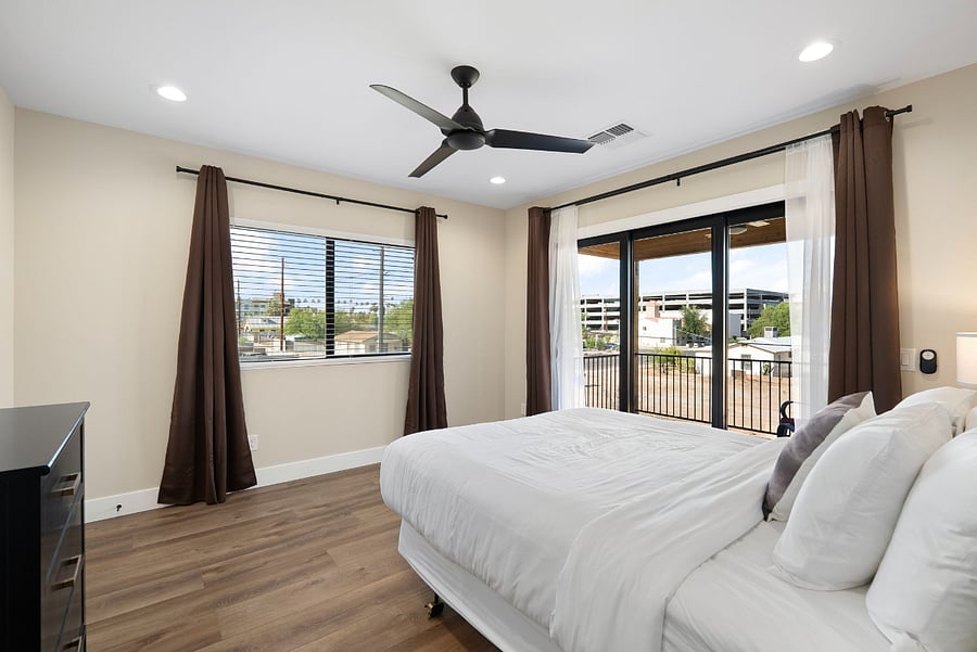 Step into a bright, airy guest retreat that seamlessly connects indoor comfort with outdoor relaxation. This spacious bedroom features crisp design choices and excellent natural light, making it a favorite spot for guests to unwind.