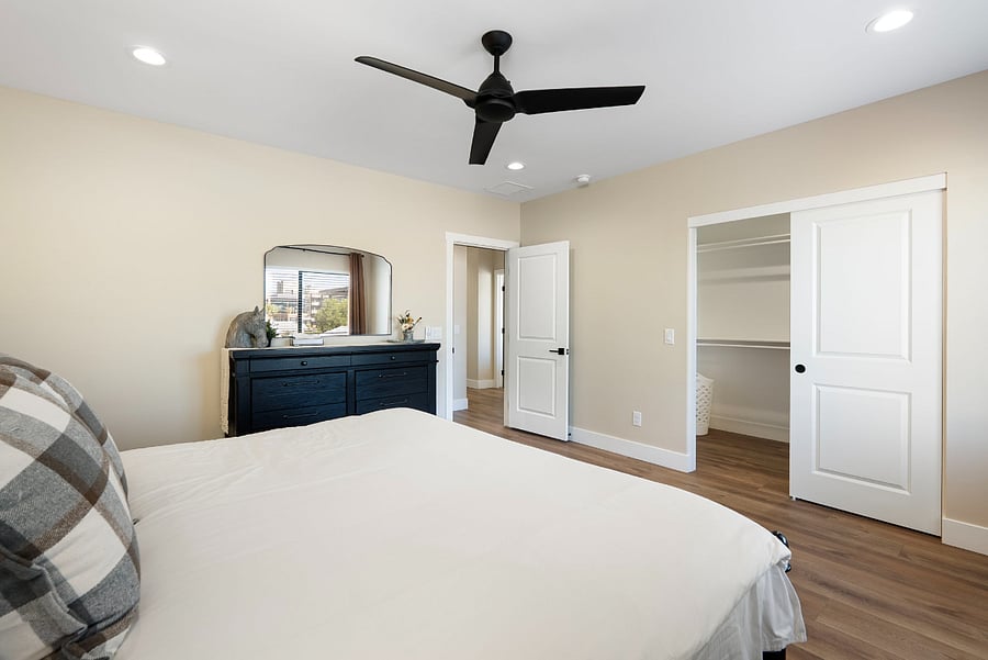 This view of the king guest room highlights its excellent storage options and functional floor plan. Positioned away from the main hustle and bustle of the house, this bedroom provides a private retreat where guests can completely unpack & relax.
