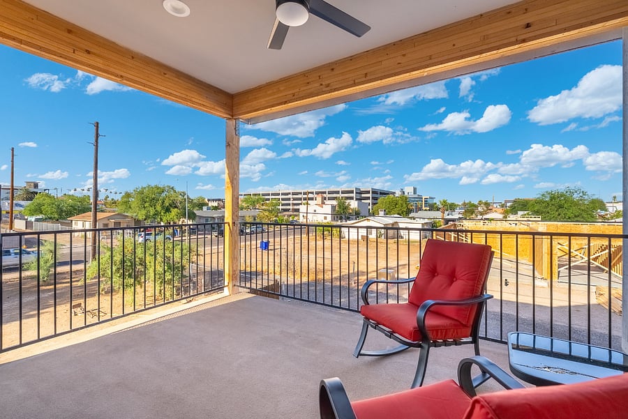 Take your indoor living outdoors with this stunning, view of your private second-story corner balcony lounge. Positioned to maximize light, air, and scenery, this wrap-around terrace provides a sweeping look at the neighborhood under open blue skies.