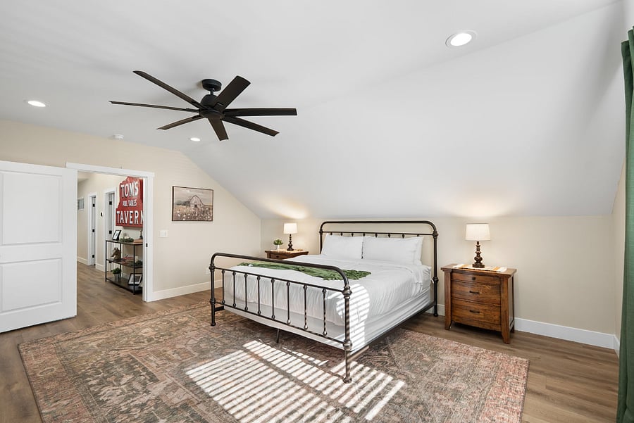 This alternate view showcases the incredible scale and open layout of the upper-level primary suite. Highlighting smooth transitions and plenty of floor space, this room offers guests a private, peaceful haven separated from the main living areas.