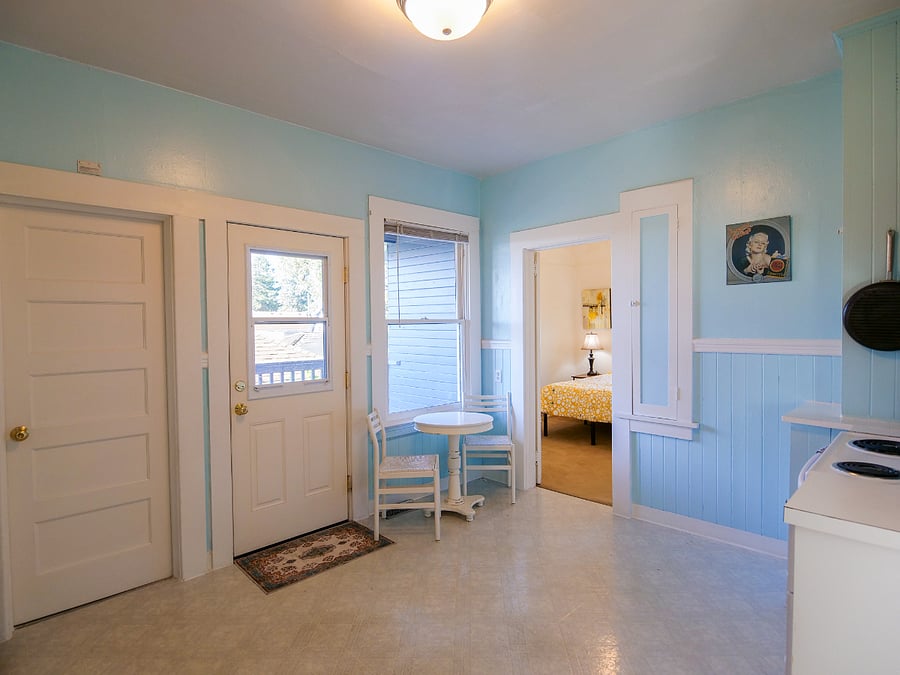 Kitchen connects to dining/living, side entrance, basement and one bedroom.