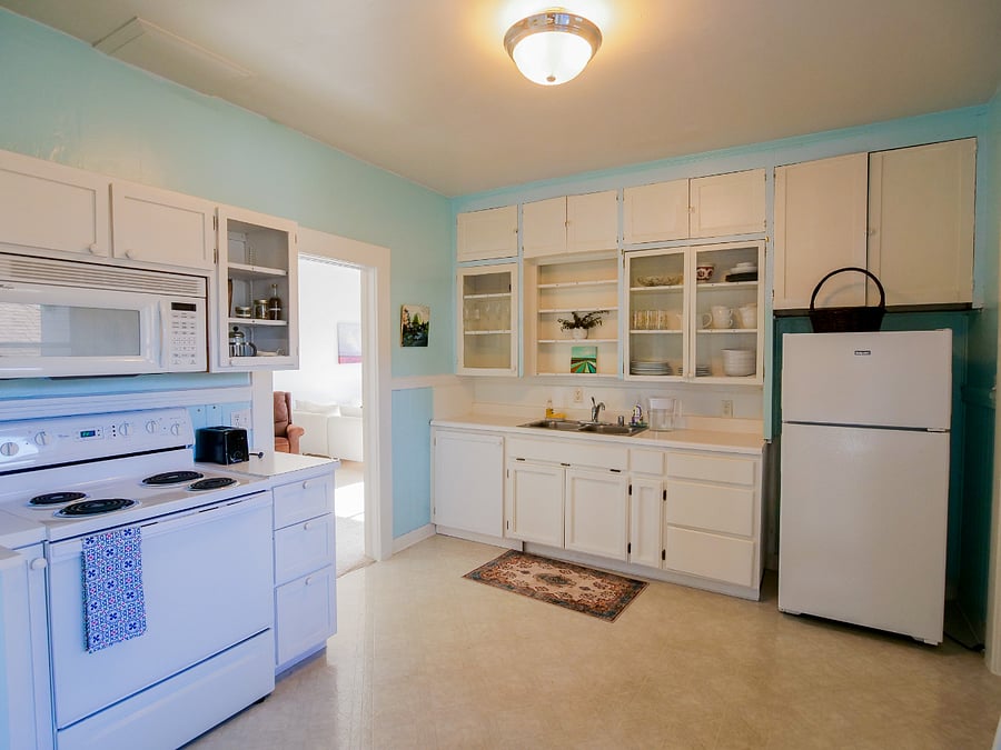 Kitchen connects to dining/living, side entrance, basement and one bedroom.