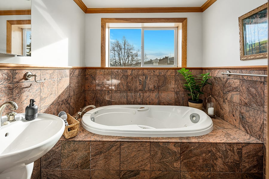 The spa like primary bathroom with soaking tub and hand shower.