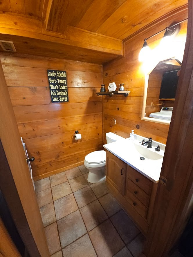 Half bath adjacent to living room with washer and dryer