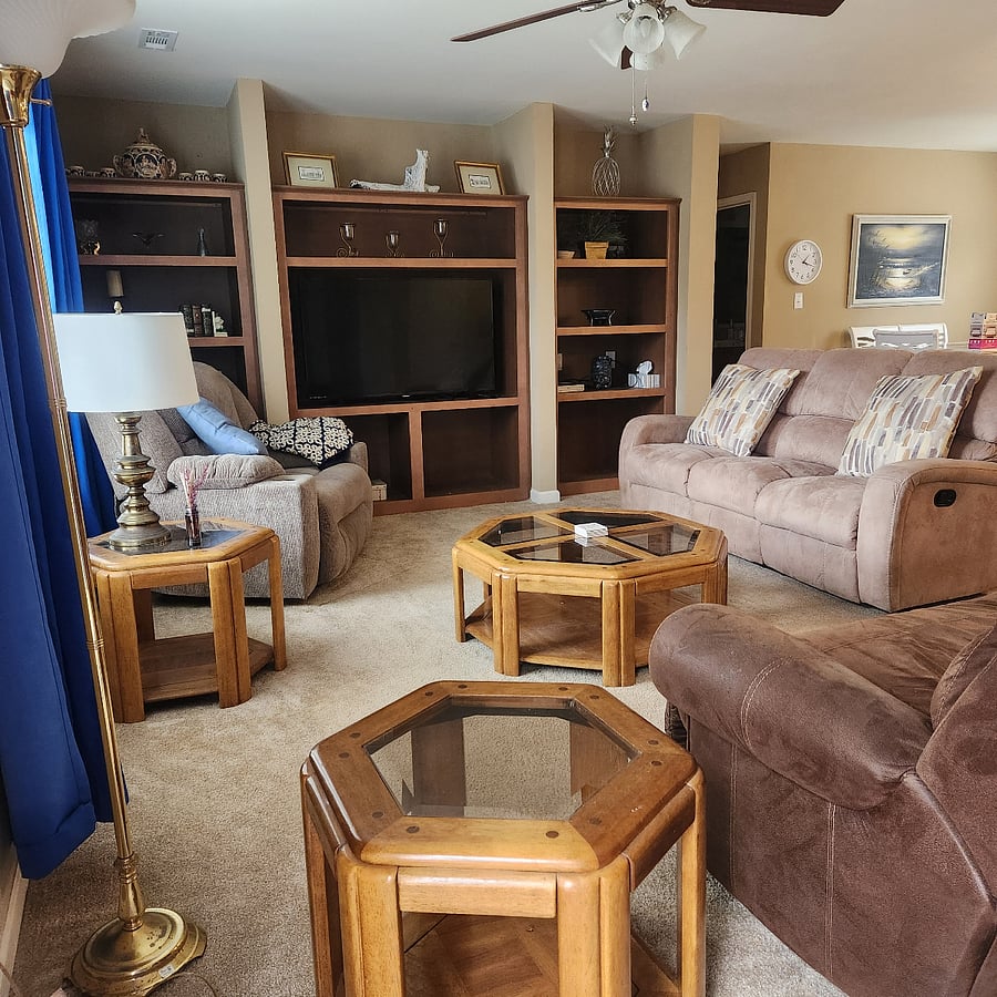 Living room with 2 oversized chairs and a reclining sofa. Smart TV