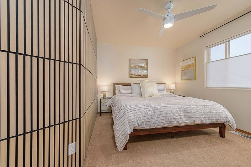 Primary Bedroom with a King bed, bathroom, walk in closet, dresser, TV and black out drapes as well as top down/bottom up blinds.