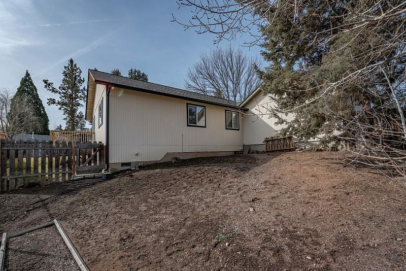 The other side of the home that is fenced and separate from the grassy yard accessed from the home.