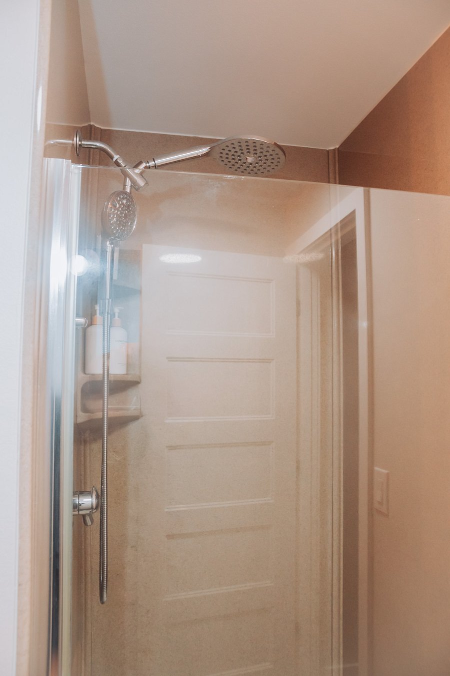Master shower which features a tall shower head and shampoo, conditioner, and body wash for your convenience.