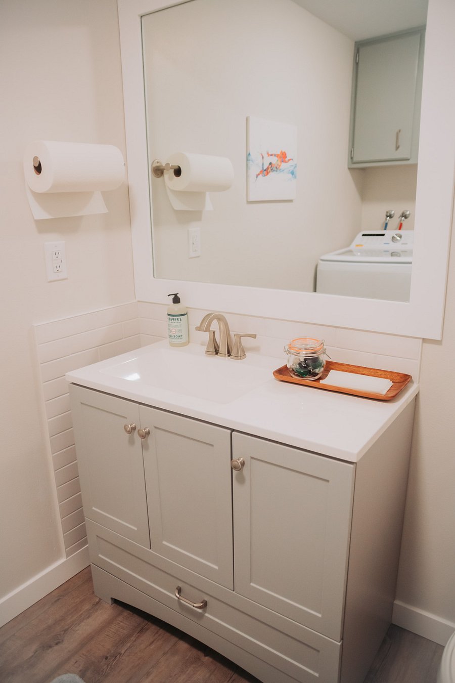 The laundry room features a large vanity with extra storage, toilet, washer and dryer, and cabinets for even more storage!