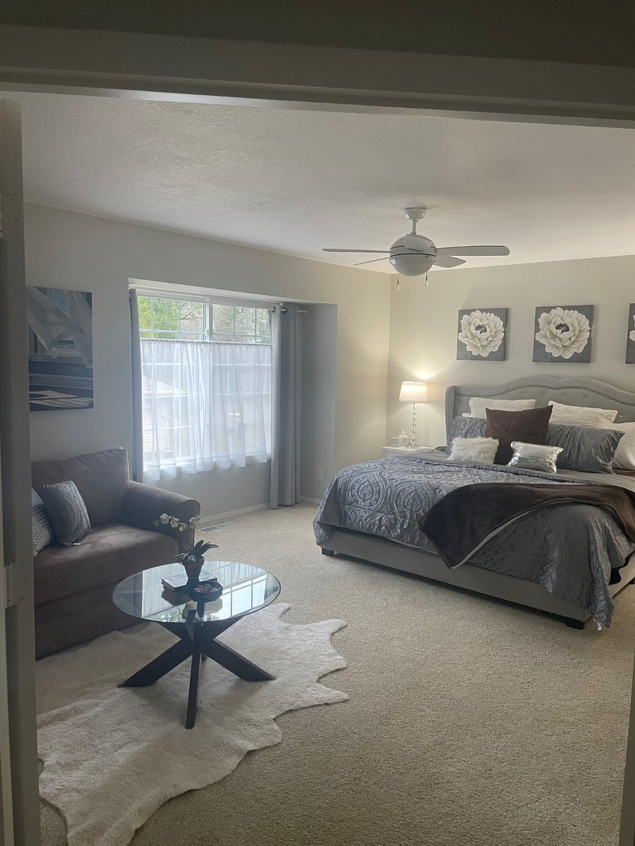 Spacious primary bedroom with sitting area, ceiling fan and en suite bathroom.