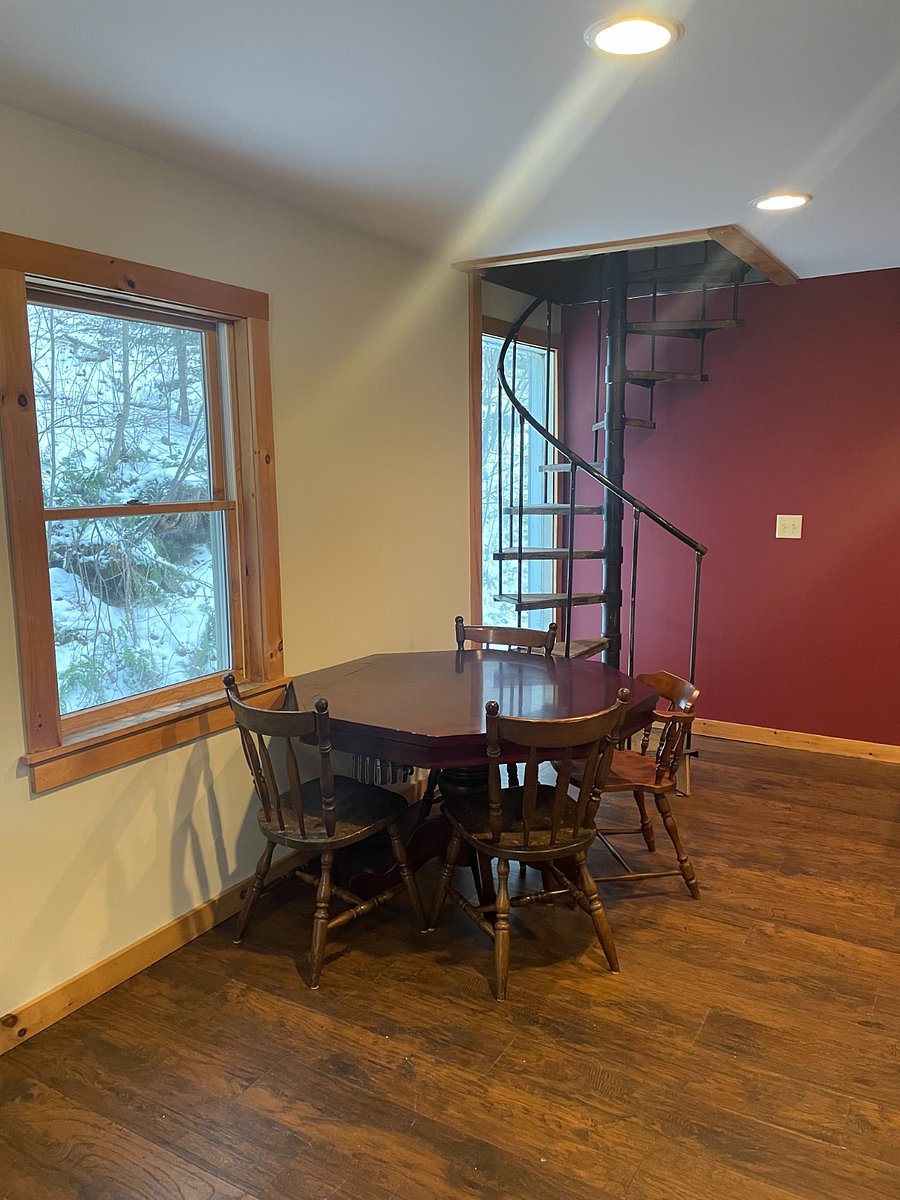 Dining table with spiral staircase leading to 2nd fl bdrms
