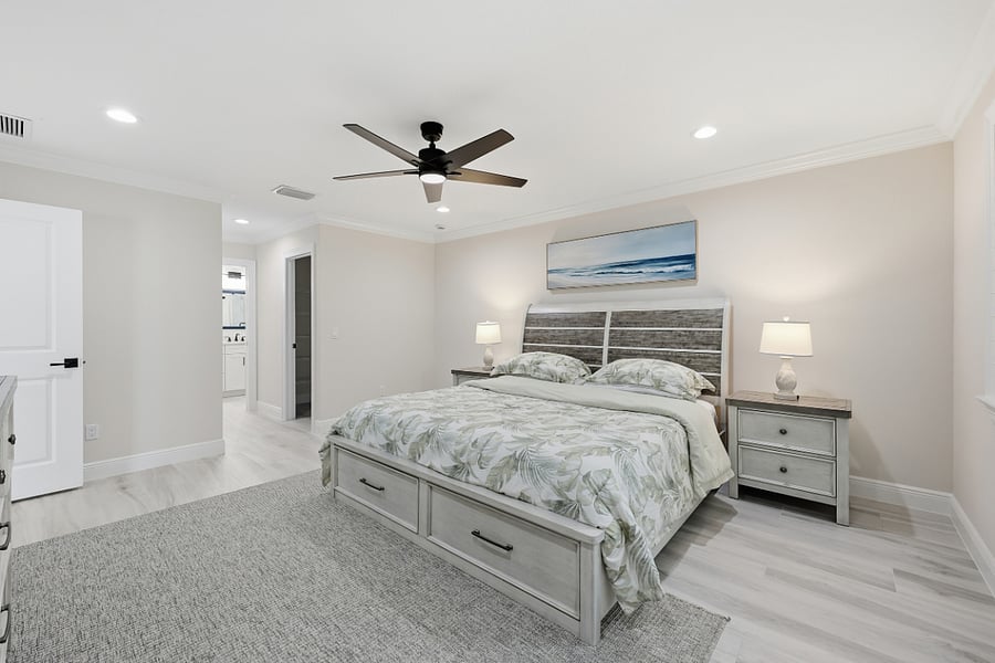 Master bedroom looking towards hallway wit two separate large walk in closets and additional closet for linens