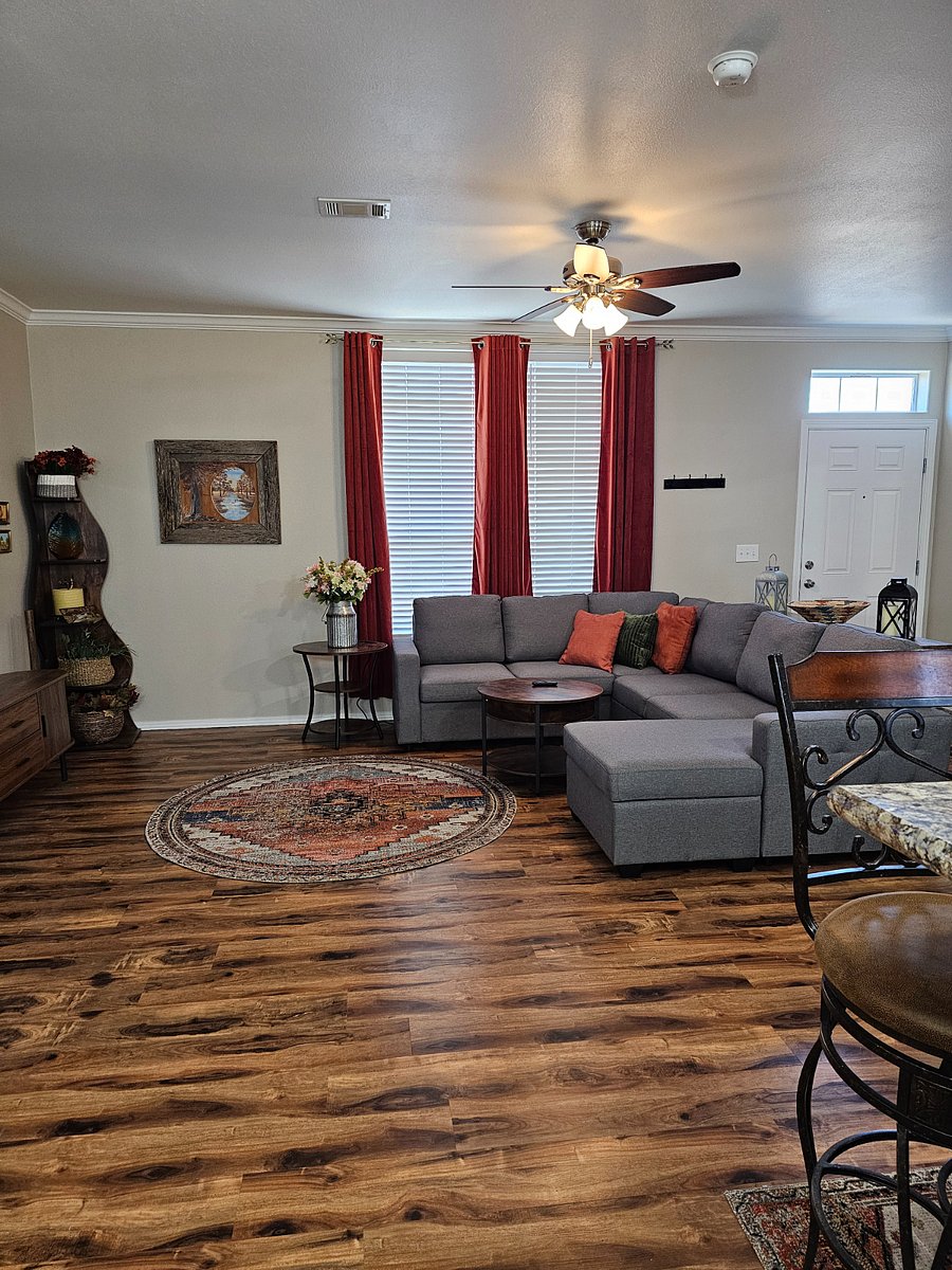 Bright and welcoming main living room featuring a comfortable sectional sleeper sofa and large TV perfect for relaxing after a long day