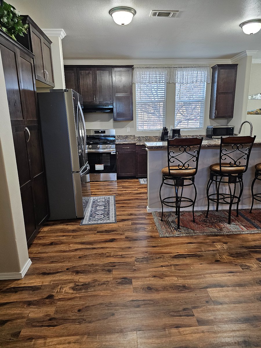 Spacious fully equipped kitchen featuring new appliances ample counter space and bar seating open to the main living area