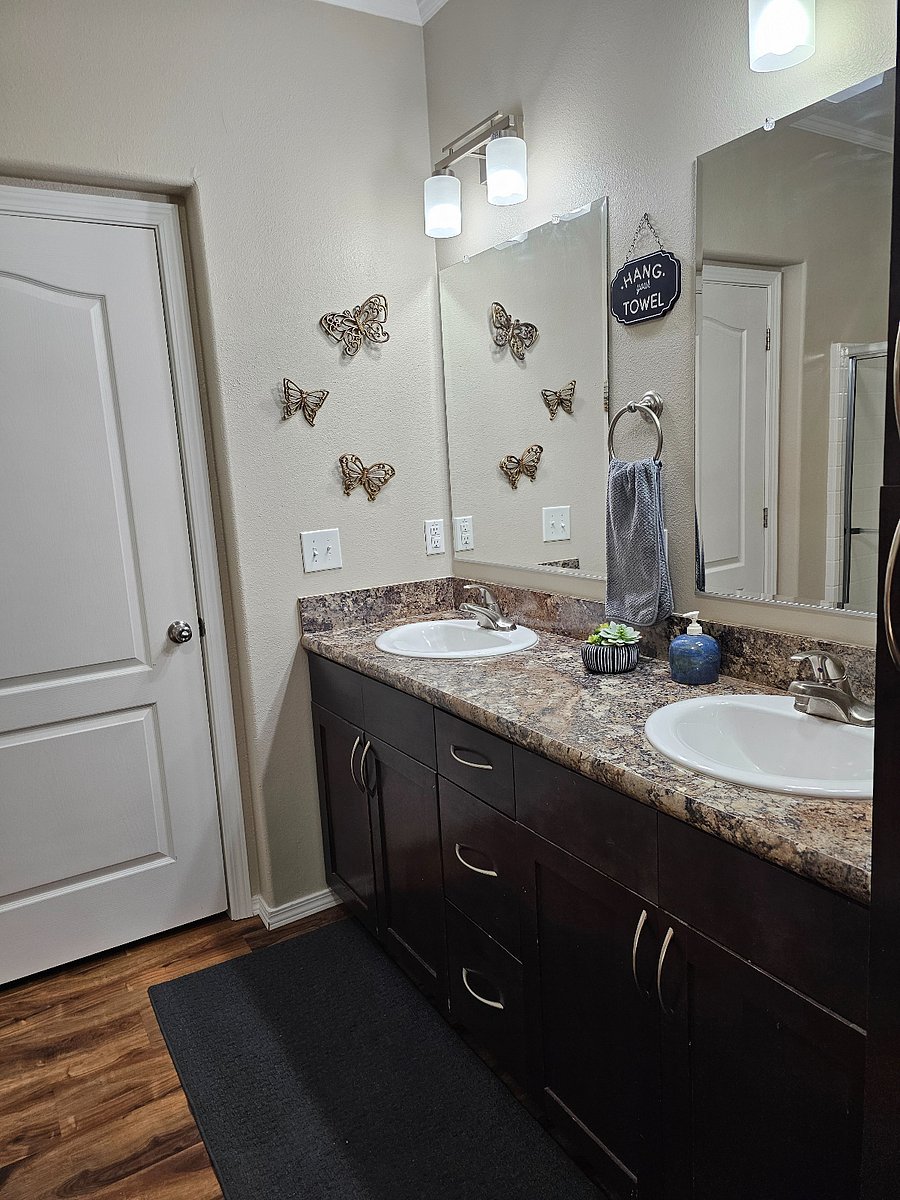Spacious main bathroom featuring a double vanity walk in shower and ample storage for guest convenience