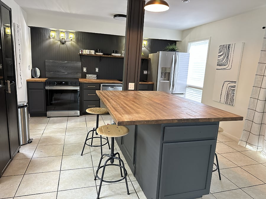 Kitchen has stove with built-in air-fryer, large refrigerator, microwave and fully equipped with pots, pans, dishes and utensils