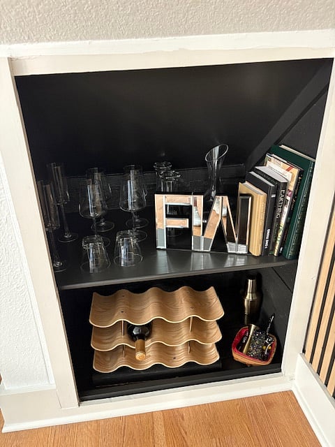 Bar supplies and wine storage tucked in convenient wall cabinet