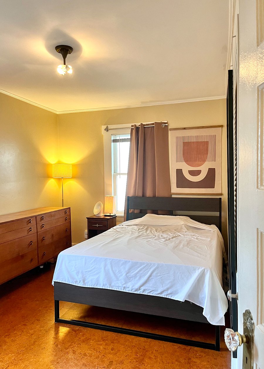 Furnished bedroom with full-size bed, dresser, nightstand